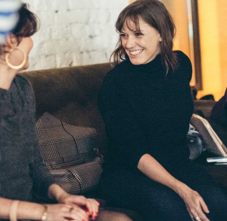 Kate Fowle smiling while sitting with a women