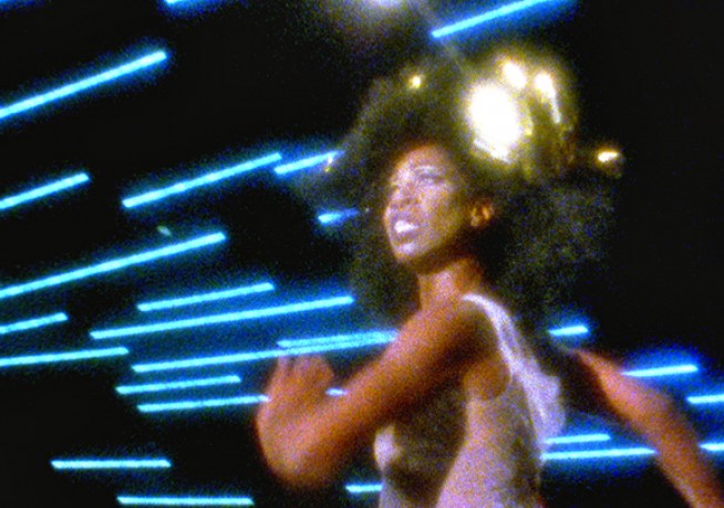 a woman wearing stylish attire and a striking gold headpiece 