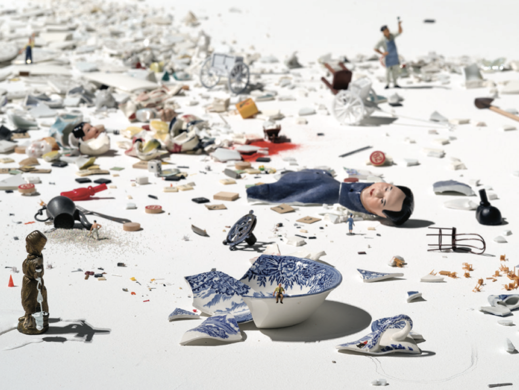 An assortment of broken dishes and objects in disarray on a white floor