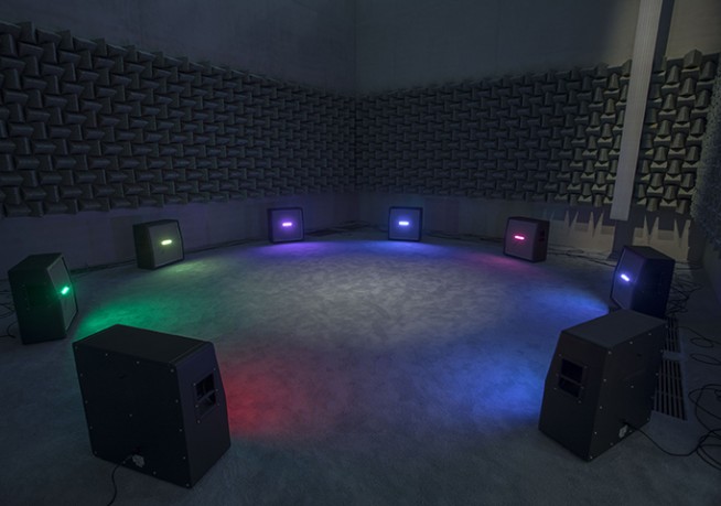 a room equipped with multiple speakers and vibrant lights 