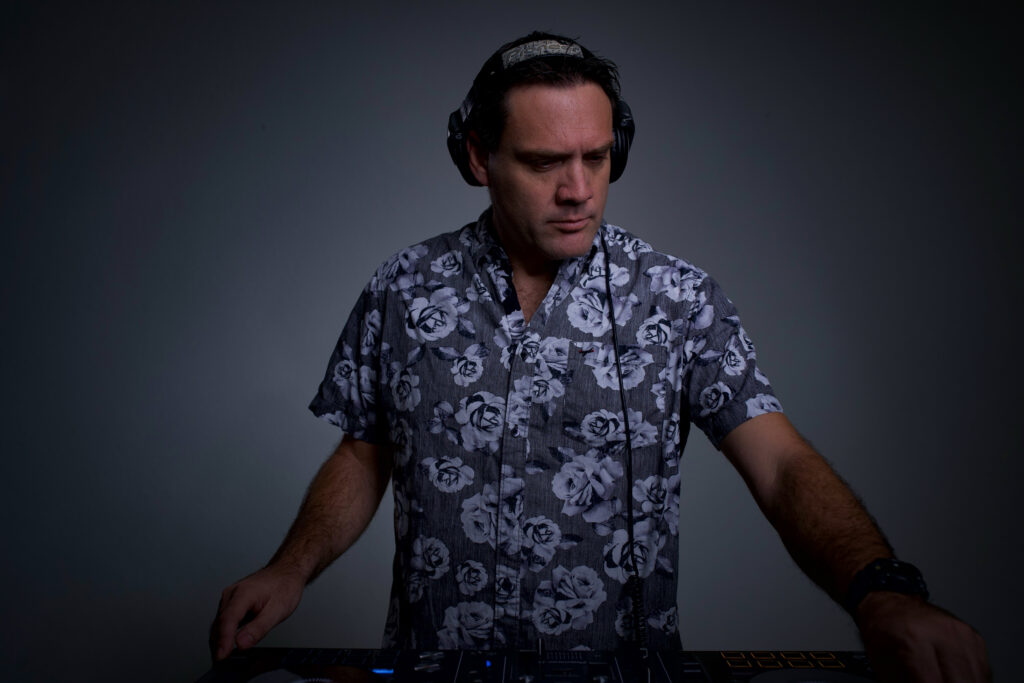 A man wearing headphones and DJing