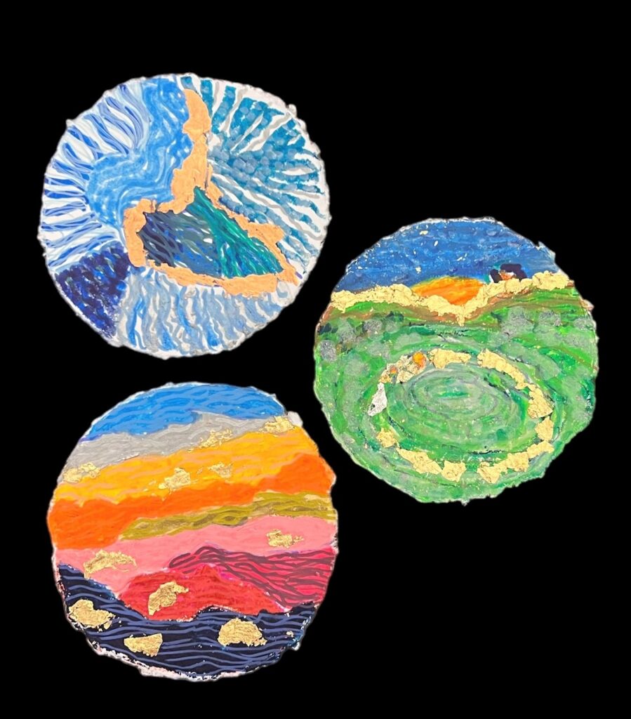 Tres obras de arte en forma redonda de diferentes colores que muestran diversos paisajes