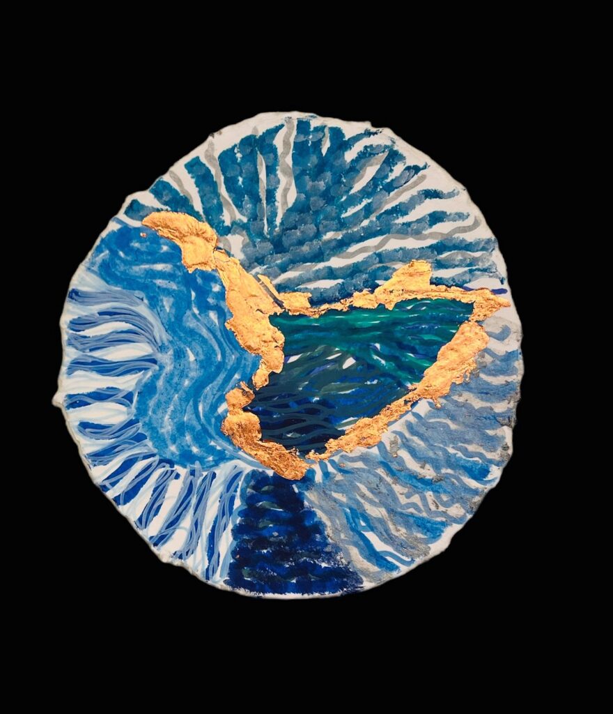 Obra de arte en forma redonda con detalles en azul y dorado que presenta un patrón de ondas