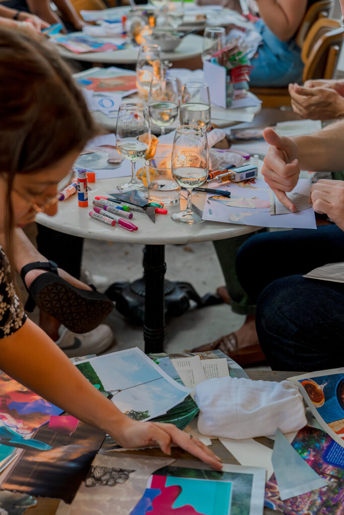 una reunión de personas cortando revistas en varias mesas