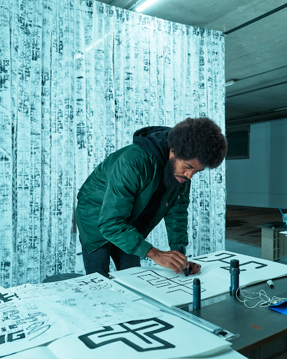 Artist painting black lines on white paper